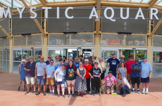 Group of people pose for picture outside of Mystic Aquarium