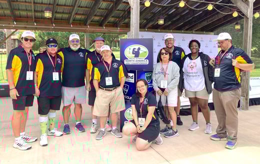 Group of people pose for picture by SONA Golf Championship sign