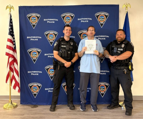 Special Olympics athlete Brian Drexler poses with two Southington Police holding athlete ambassador certificate